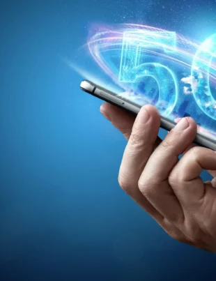 A digital illustration of a 5G logo between a human and robotic hand, set against a blue glowing city and network grid, representing Pakistan’s move toward 5G services.