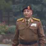 Libyan army chief in military uniform wearing a beret and medals during an official appearance.